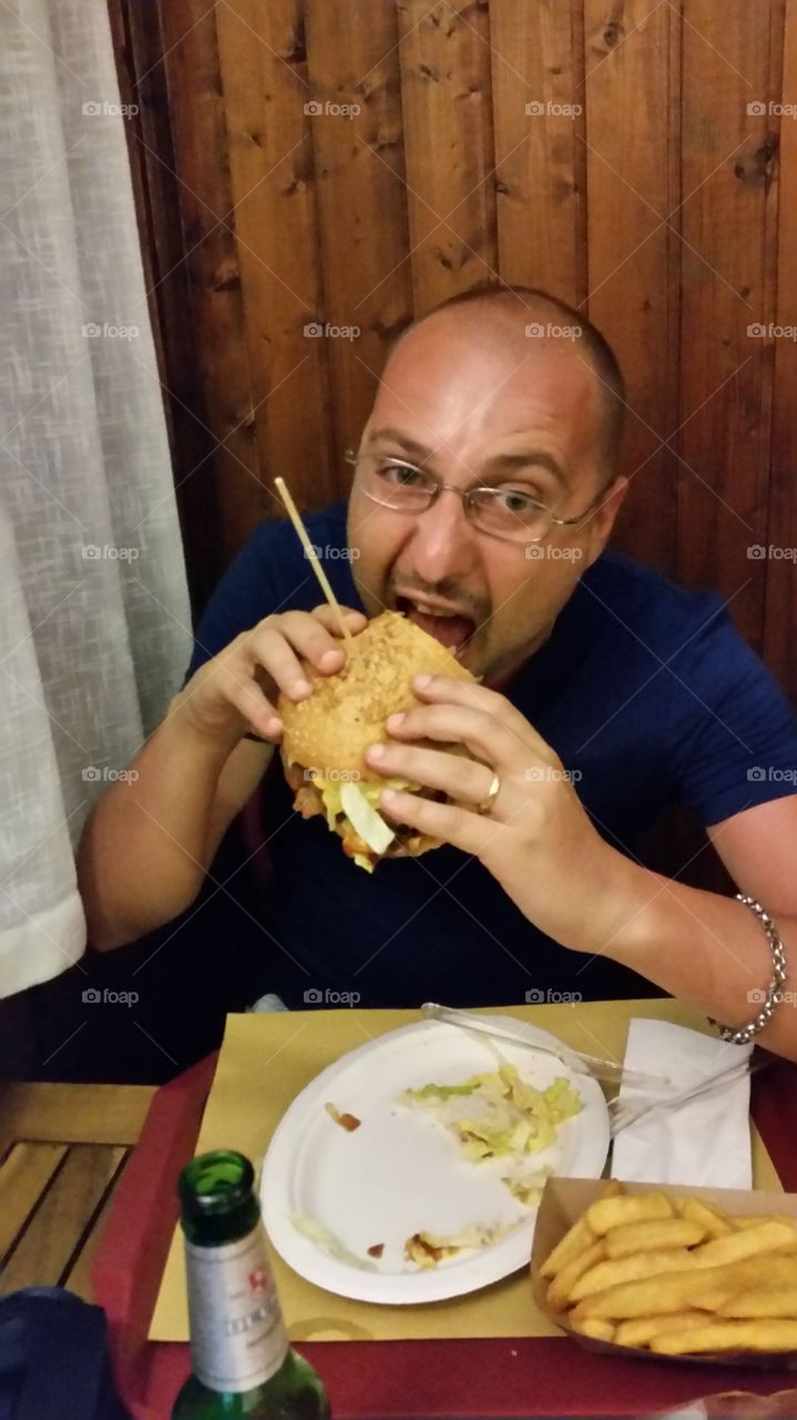 Close-up of a man eating burger and French fries