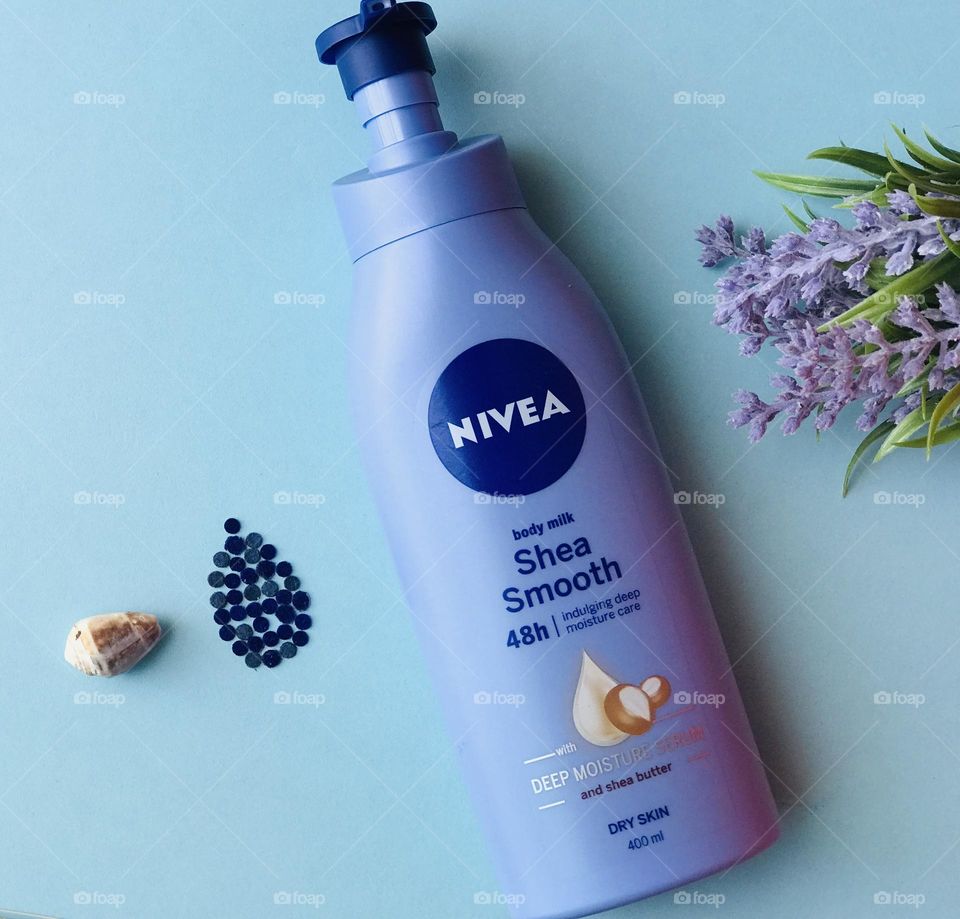 Nivea body lotion and lavender flowers and shell and cream drop symbol.lotion drops from shell.