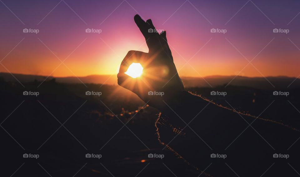Making hand shapes during sunset