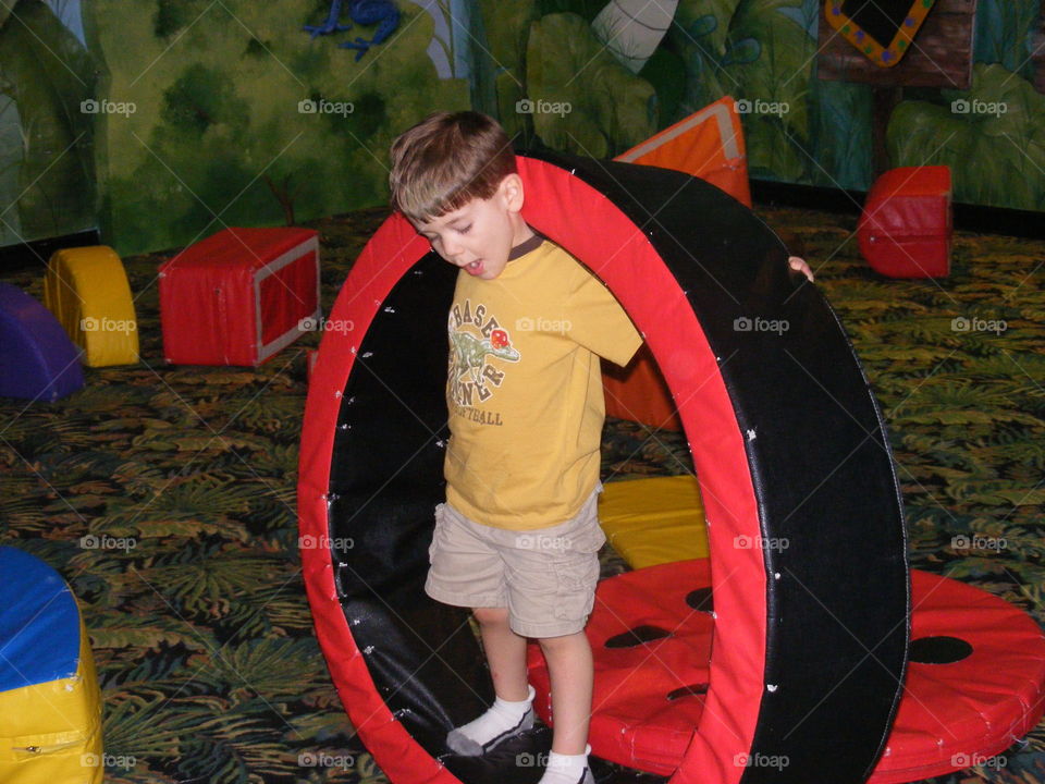 Boy playing with a loop at on indoor playground.