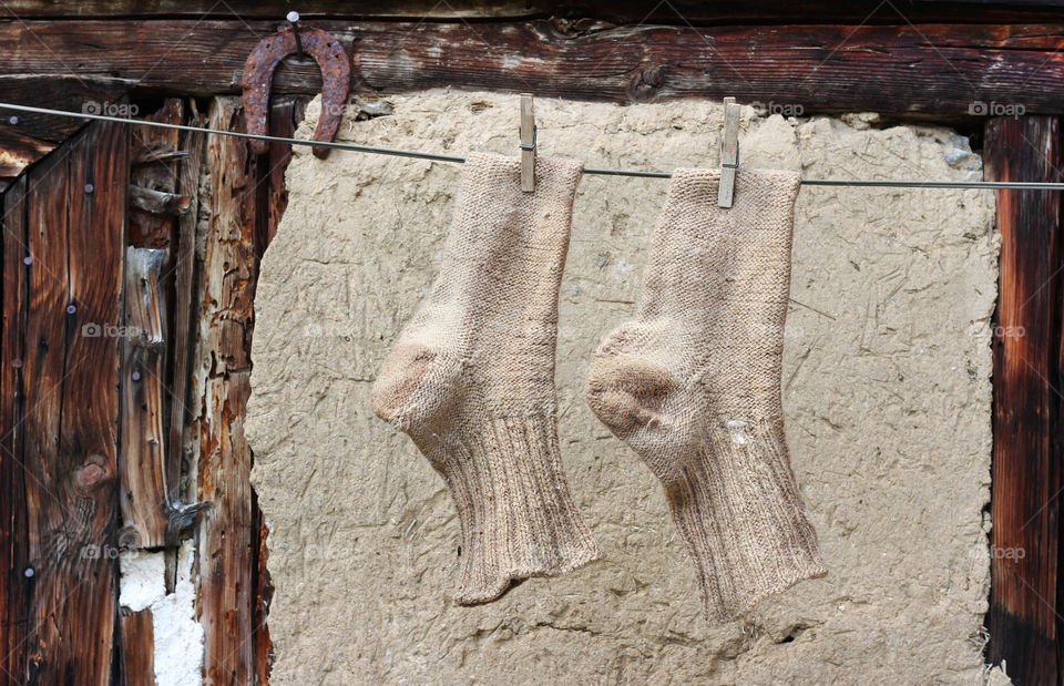 Hand knited socks drying on the rope outdoor, autumn mood, brown color, country life