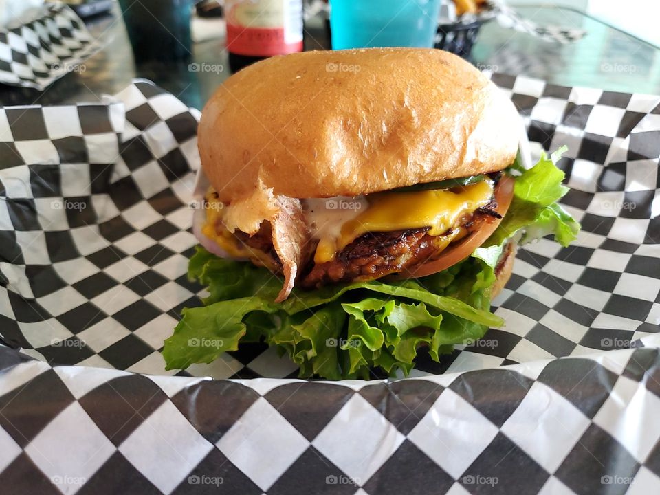 Vegan burger on black and white checkered paper.