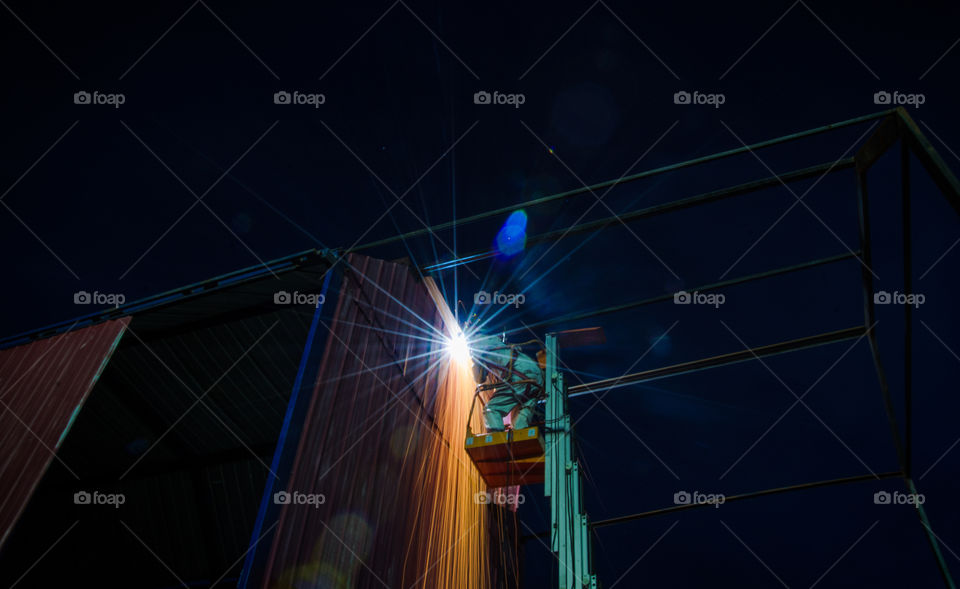 man welding at night