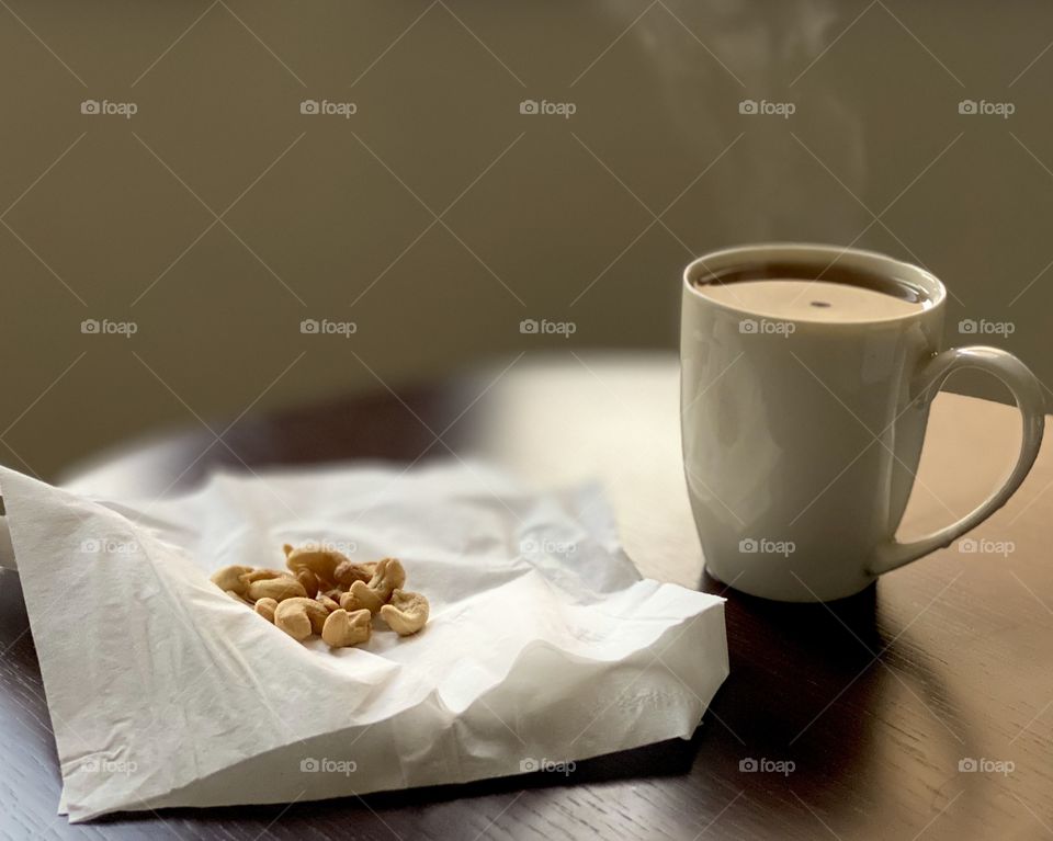 Cup of coffee and cashew nuts photography, photo of cup of tea and snacks on the table 
