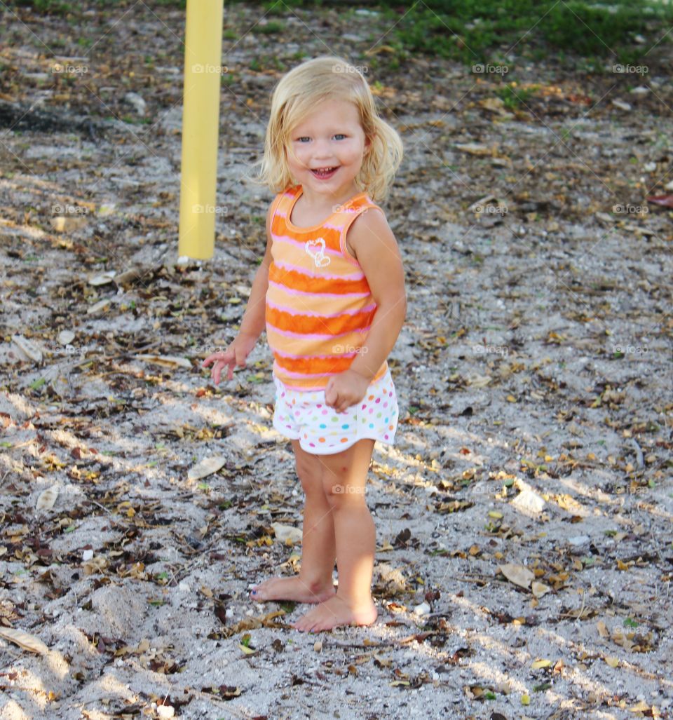 Portrait of a little girl standing on sand