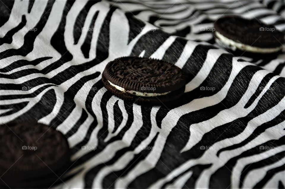 oreo chocolate cookie with white cream on zebra black and white background close up