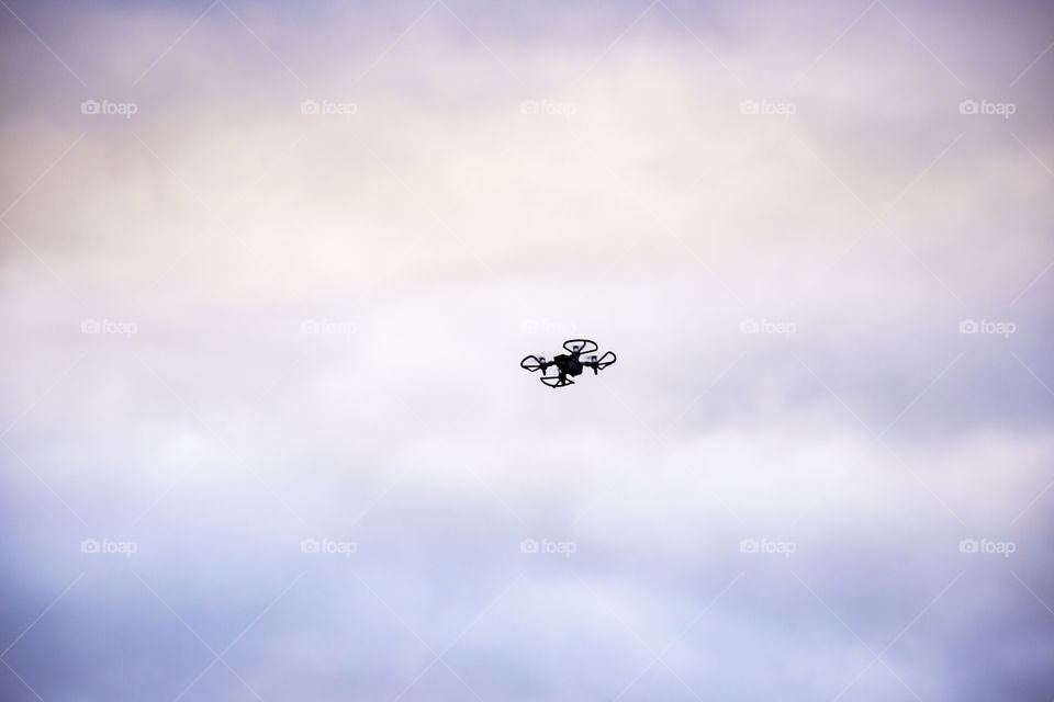 Black drones flying in the sky With many cloud and morning light.