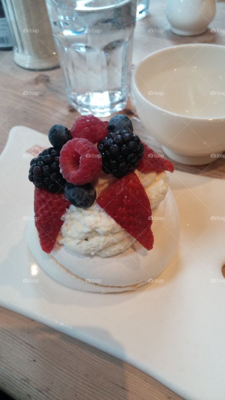 Fruit pavlova with sweet whipped cream and juicy, ripe berries!