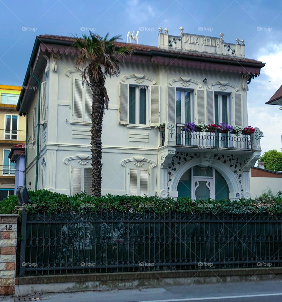 Old white beautiful building in Rimini Italy palm tree