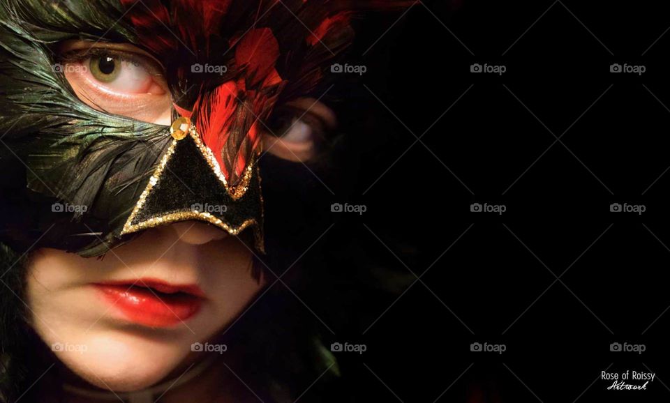 Woman with a black and red venetian mask wearing red lipstick