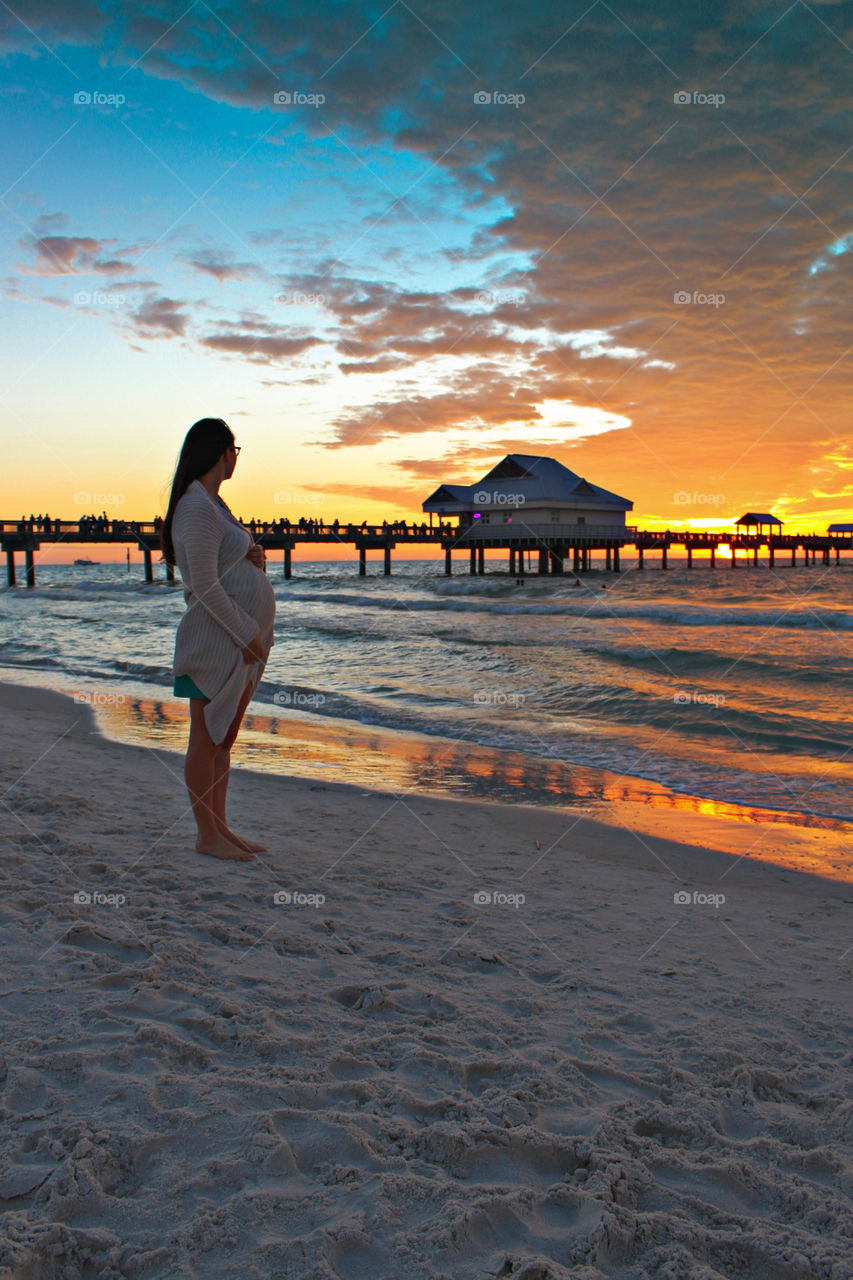 pregnant women on beach at sunset