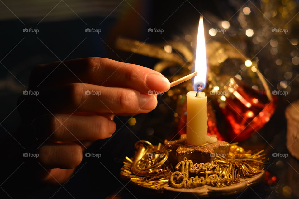 Human hand lighting christmas candles
