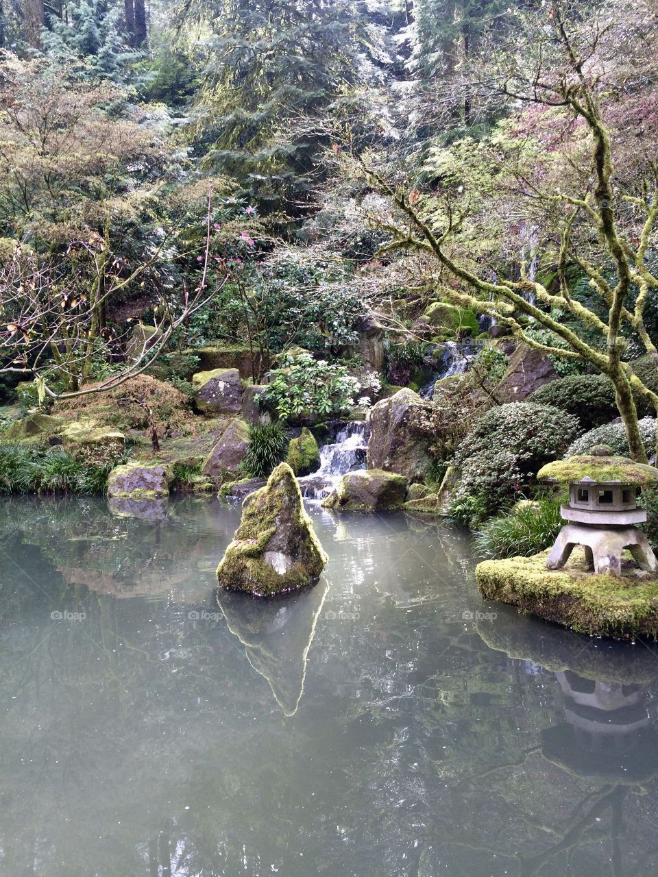 Japanese gardens during spring. Moss on the statues. Reflections in the water. 