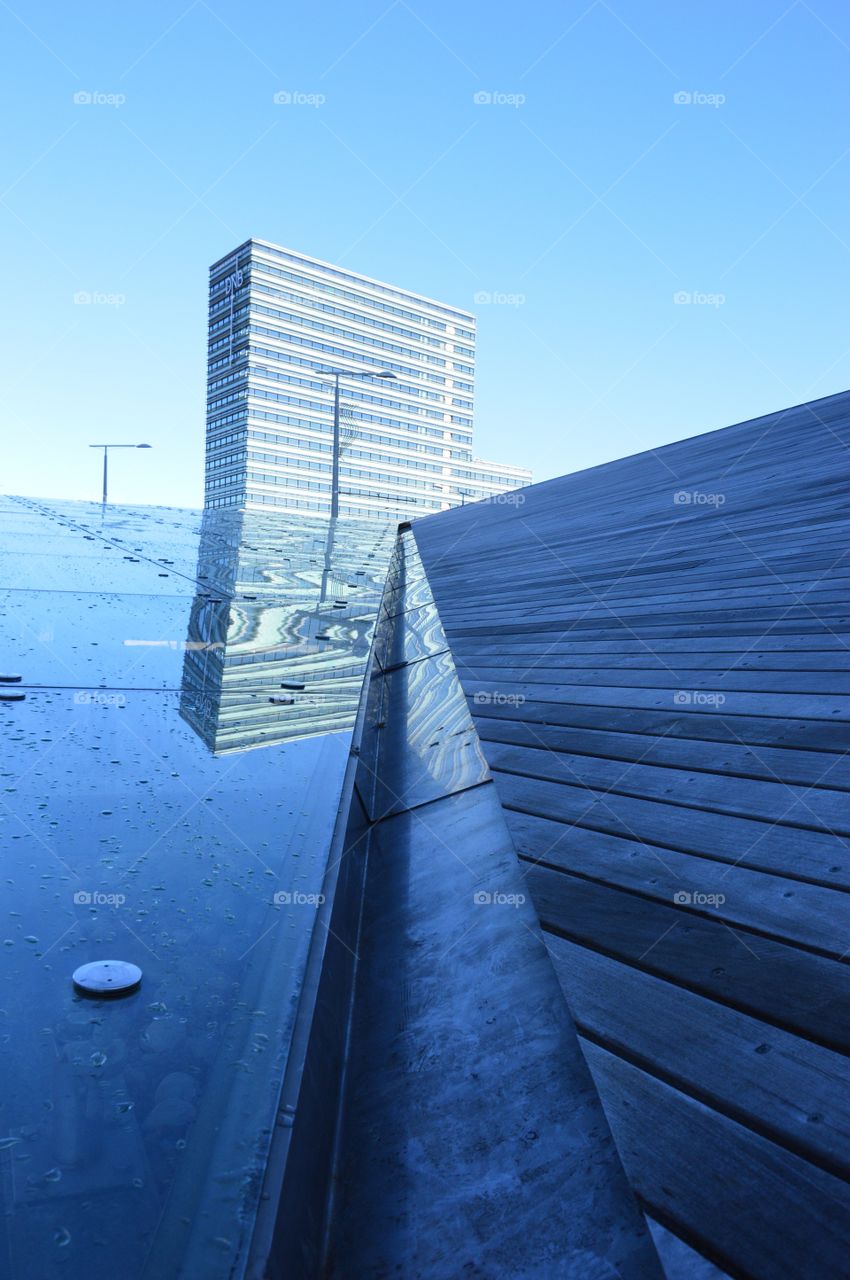 Looking at roof, sky and glass building at once