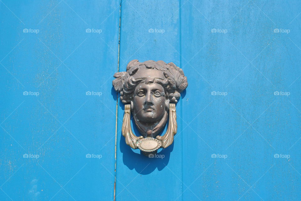 Blue door with a handle in the shape of a guy's head