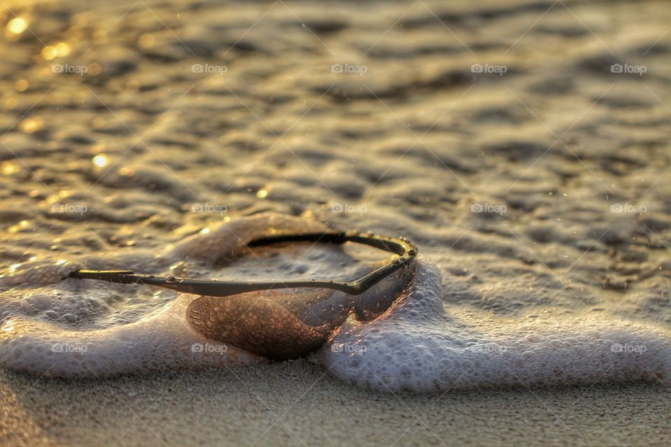 sunglasses submerged on sea waves