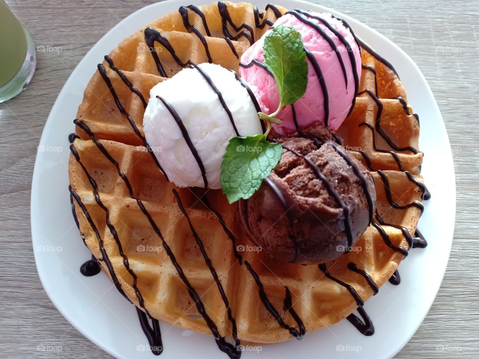 waffle with topping ice cream 3 taste, chocolate, strawberry, and vanilla.