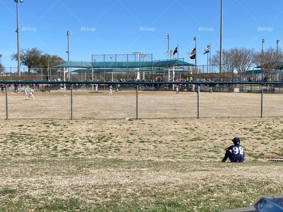 A baseball player sits looking the outfield while reflecting on his craft.