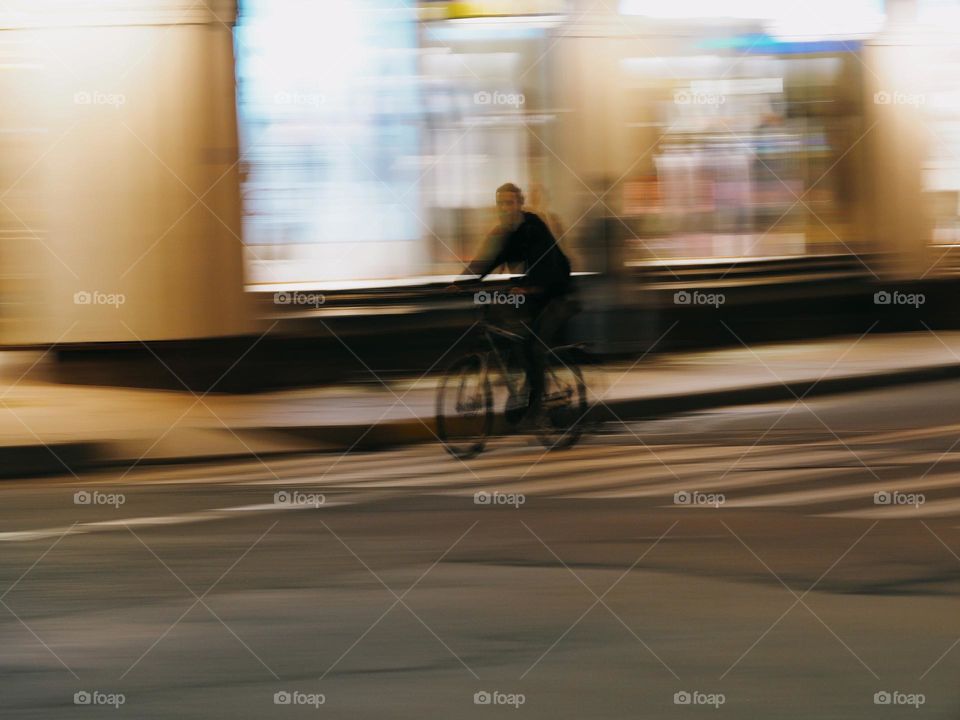 Men on a bicycle riding on night street, long exposure 