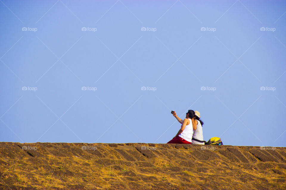 A couple having fun at a beach while taking a selfie