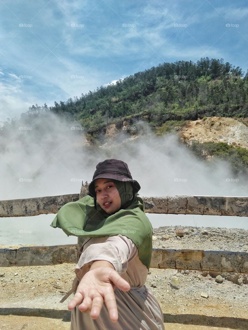 A girl is taking pictures at a crater tour in the mountains.