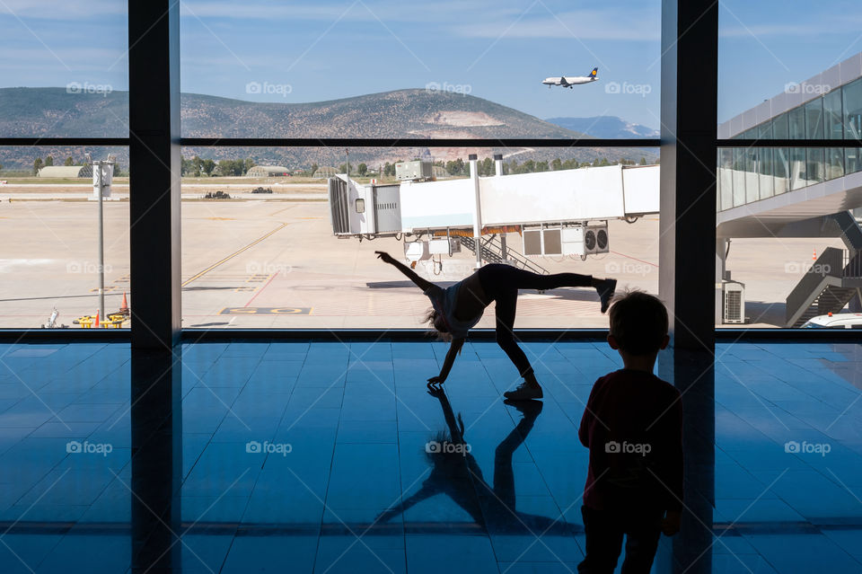 Girl doing cartwheels exercise out of boredom while awaiting for her flight.