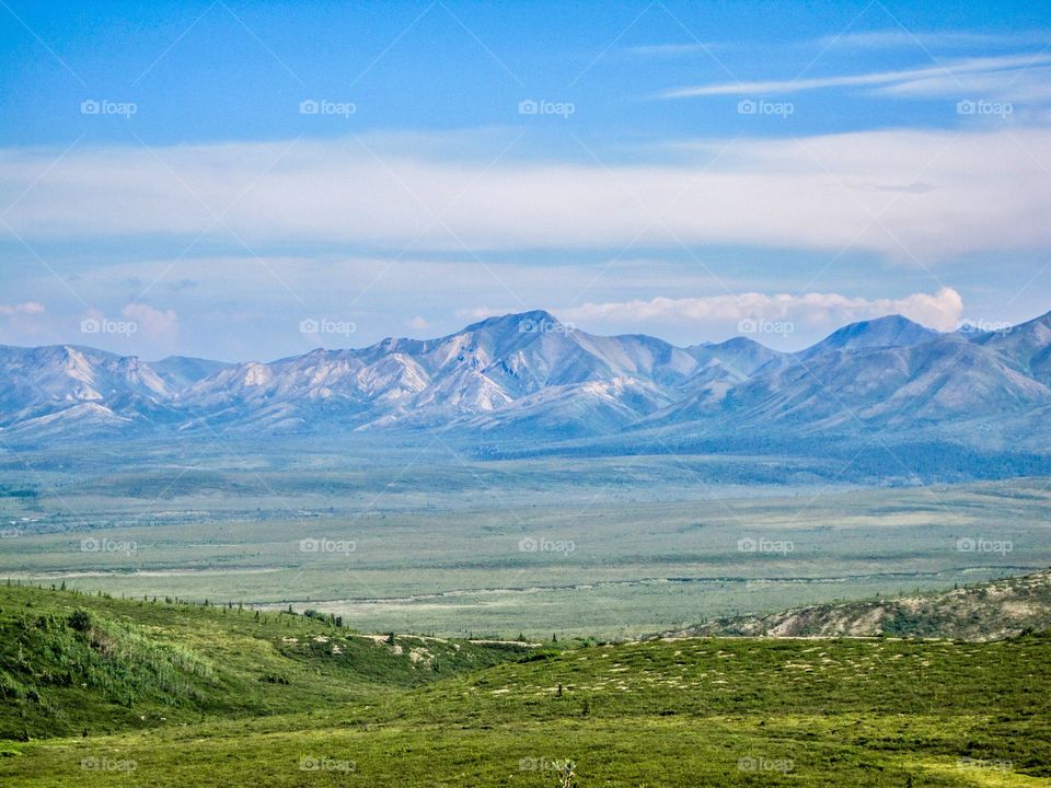 A distant mountain in Alaska with a large and vast field in front 