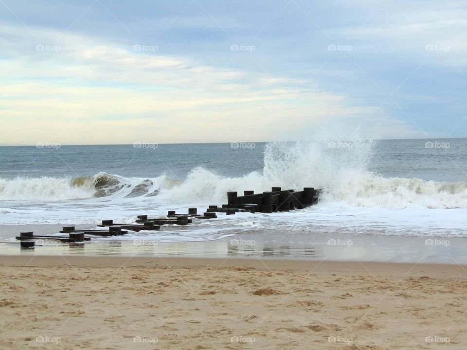 Waves crashing against a sunken pier. 