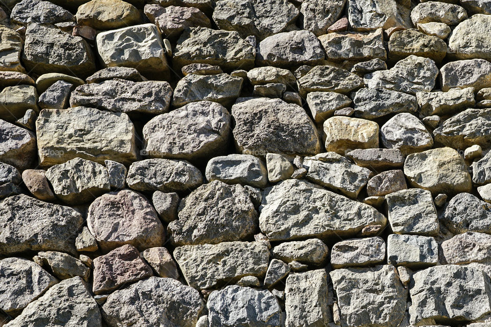stone wall background of historic ruins, composition of natural stones forming a wall with gray tone