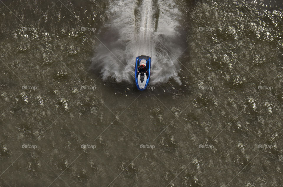 From an altitude measuring more than 400 feet atop the George Washington bridge a man rides a wave runner through the hudson.