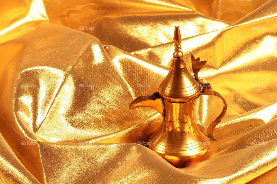 Traditional Arabic coffee pot Dallah on gold background