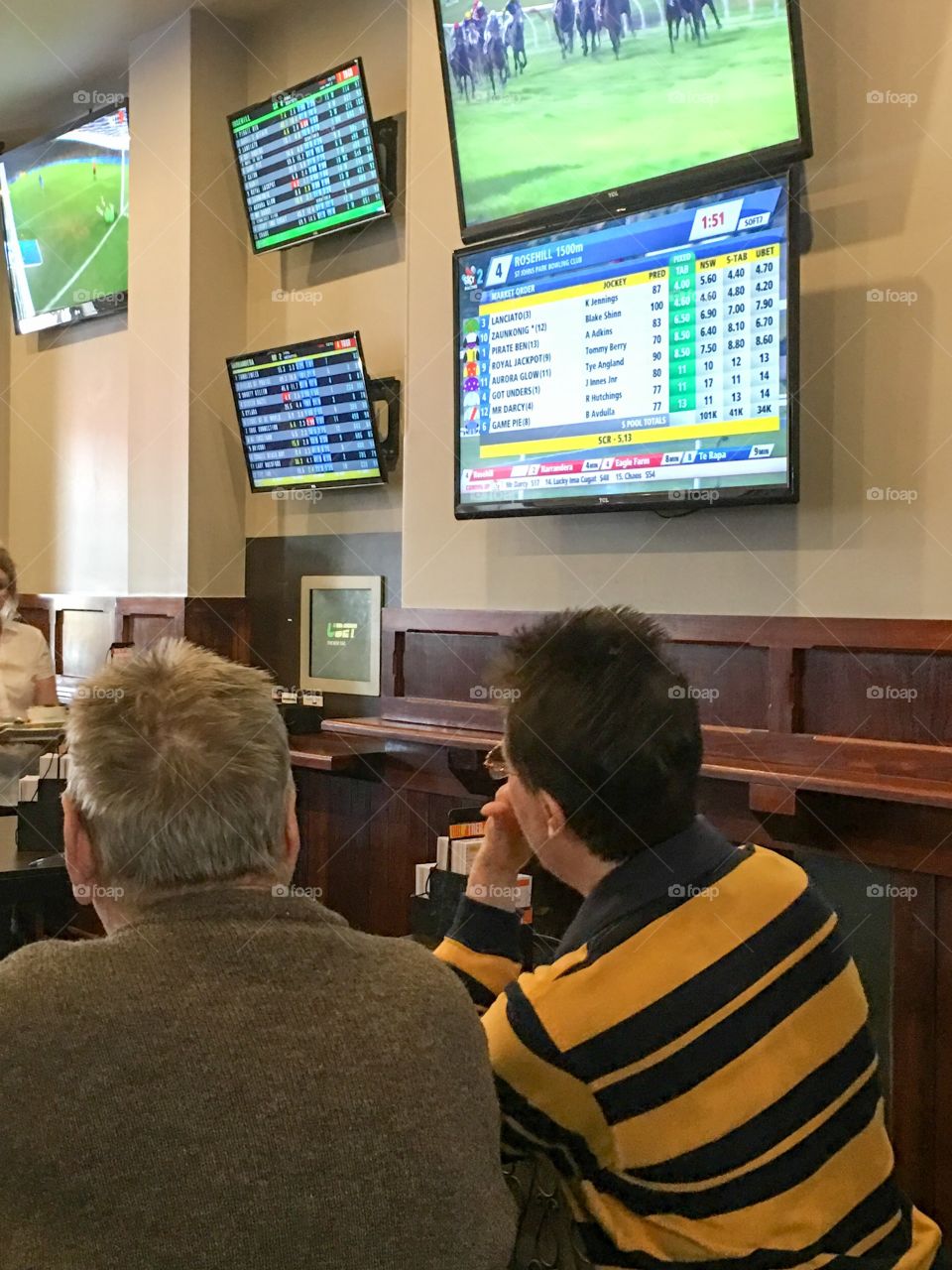 Horse racing betting inside a pub people watching the screen