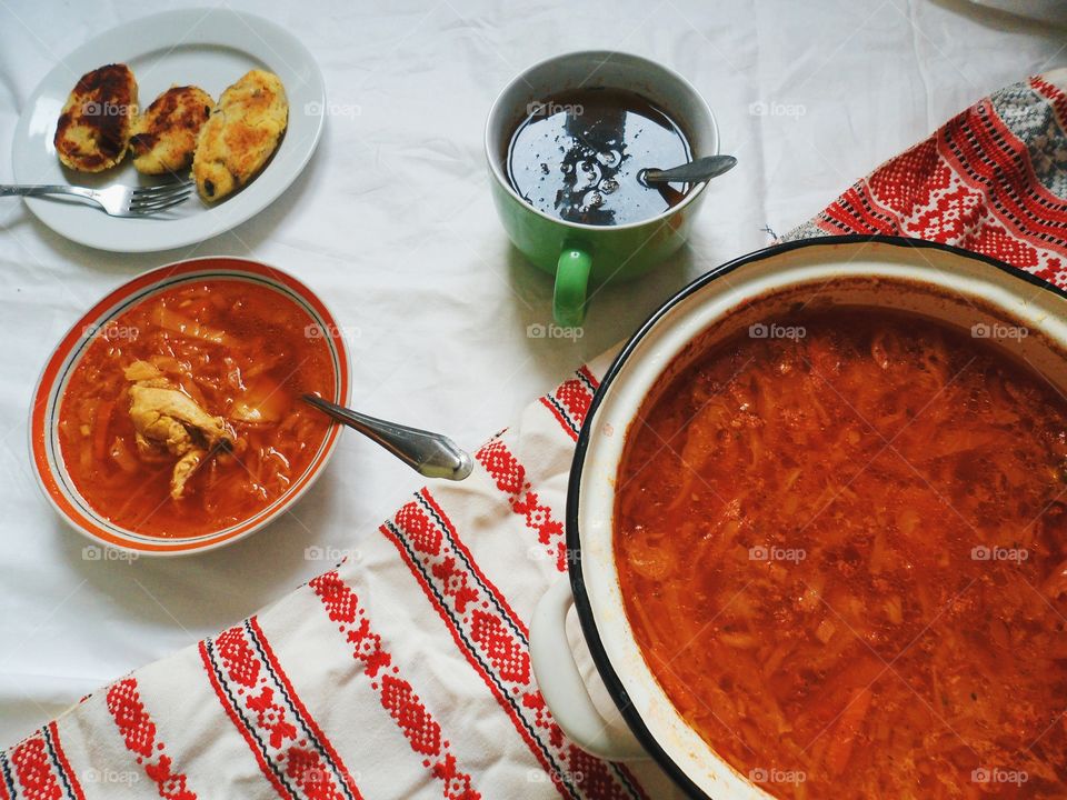 Ukrainian borscht, pies with meat and a cup of tea on the table