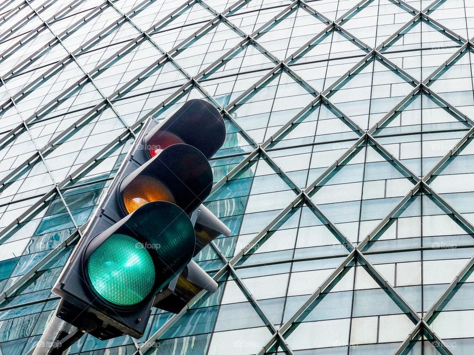 Close-up of traffic light against a steel and glass office facade