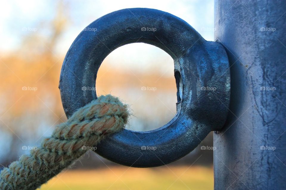 Close-up of rope tied up on metal ring