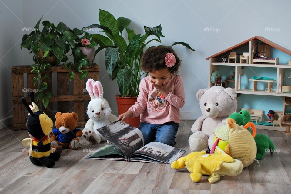 Girl Reading book for teddy bears