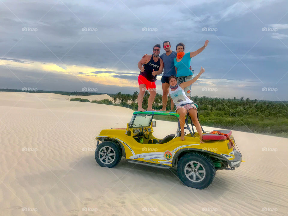Four friends in the buggy on the white dunes 