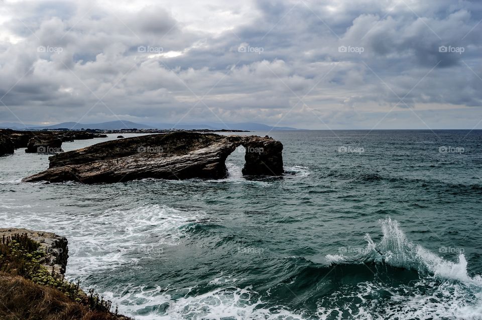 Idyllic view of sea against cloudy sky