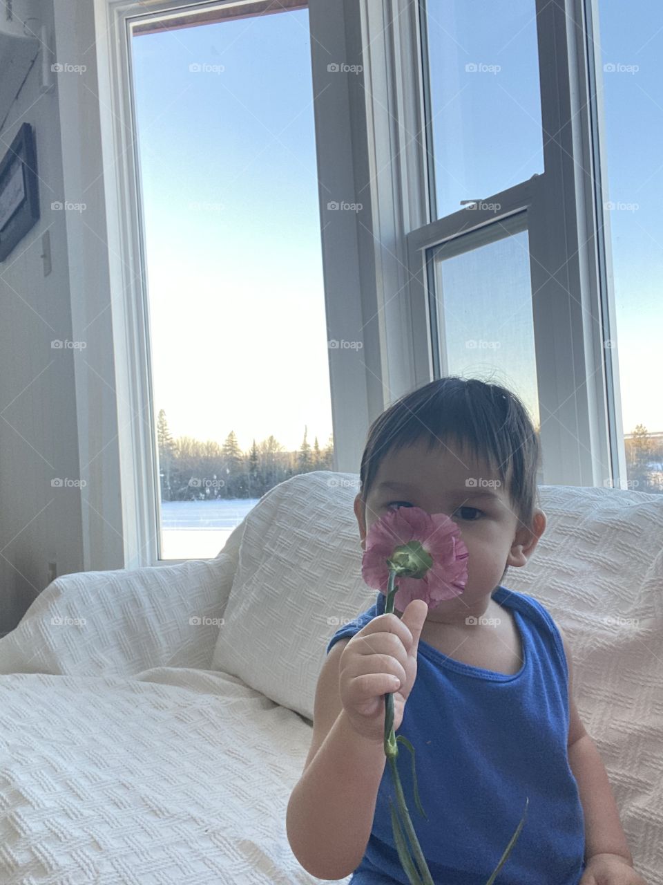 Toddler smelling flower
