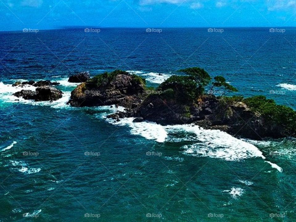 Beautiful Blue sea with hillside island with water waves and splashes