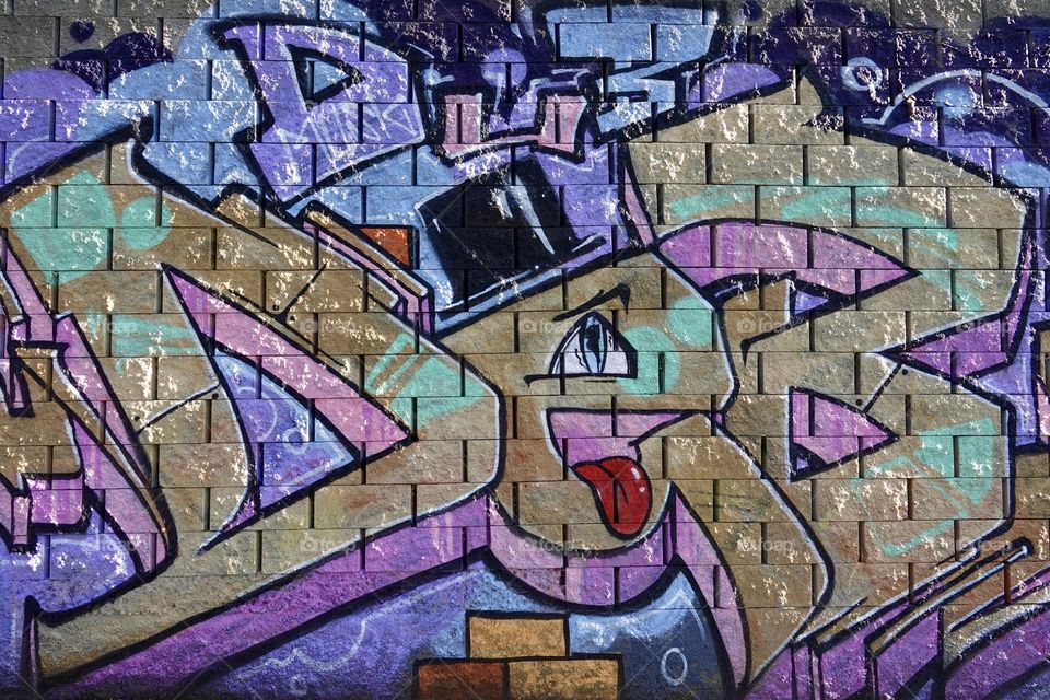 Colorful abstract graffiti and lettering on the brick wall by the path in Krejcarek park in Prague, Zizkov.