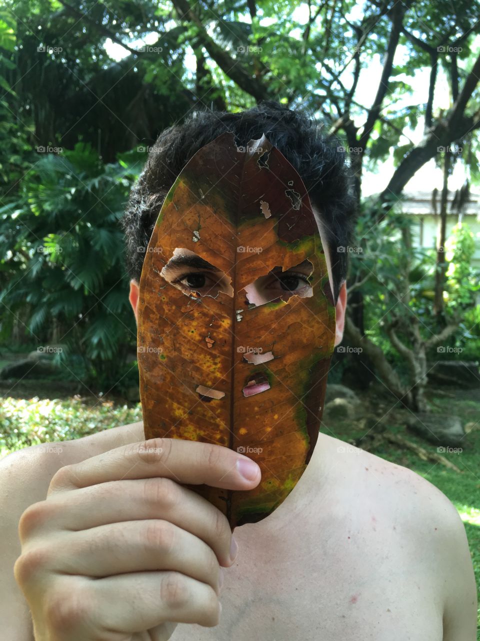 Man with tropical leaf as face mask