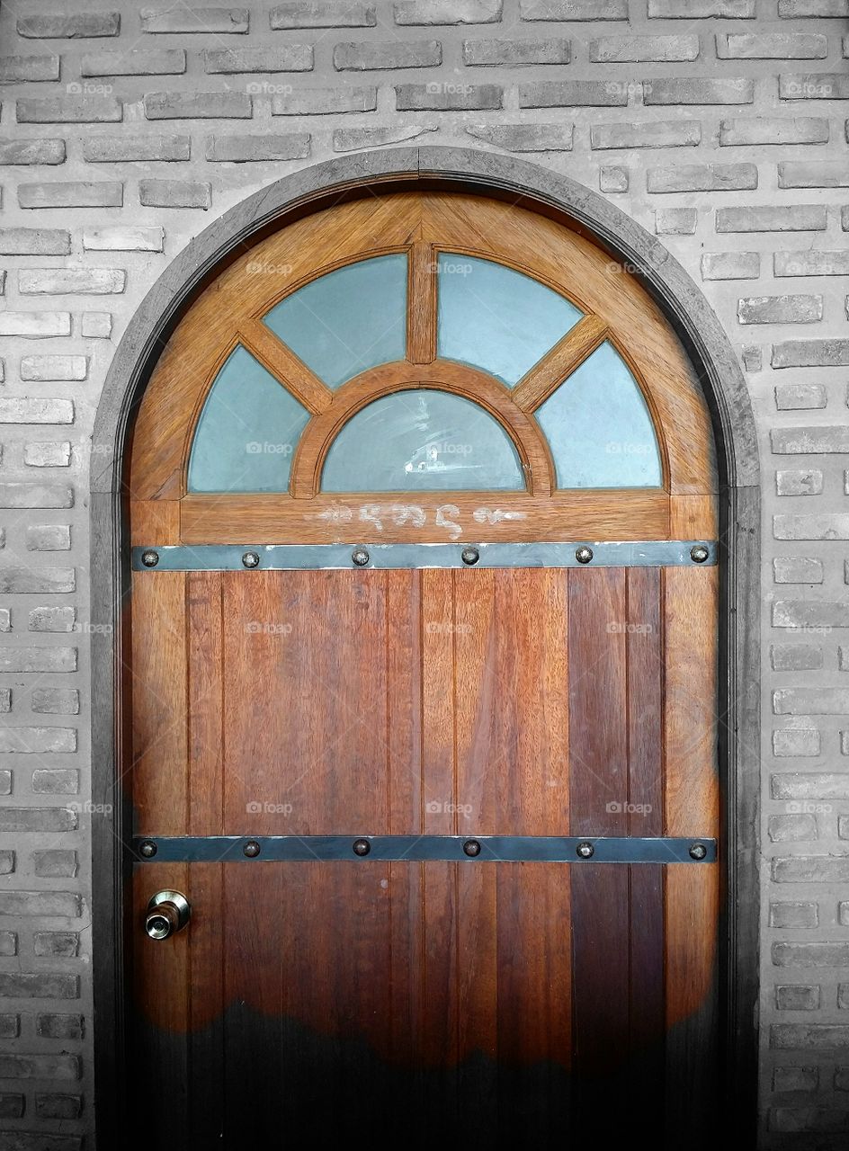 Beautiful wooden door on the brick wall.