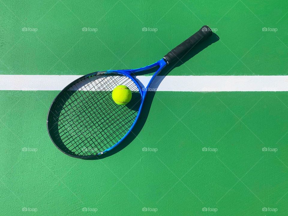 Tennis racket on green court