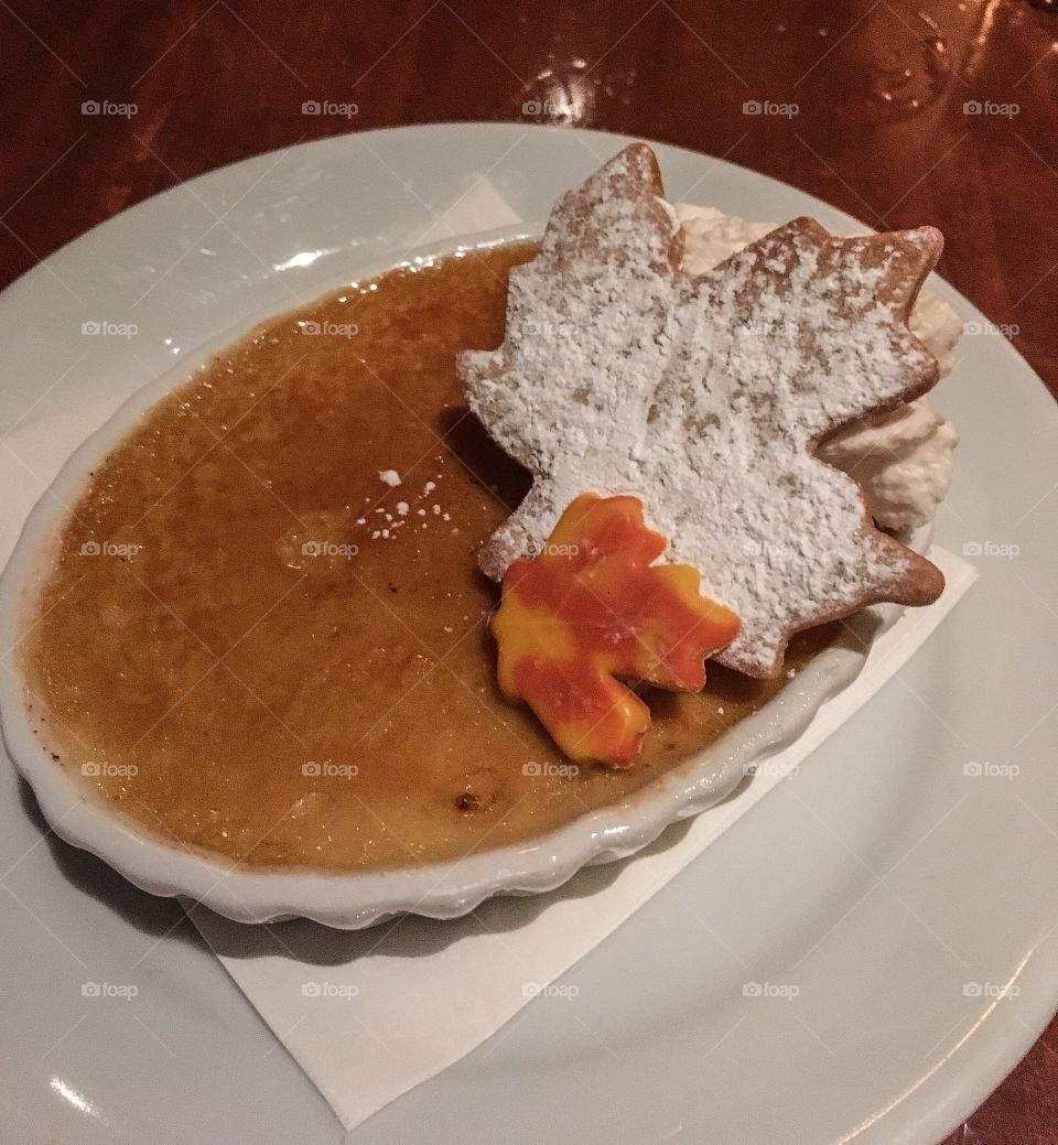 Delicious dessert. Maple creme brûlée with cookies shaped in the form of maple leaves and dusted with powdered sugar. Yum! 