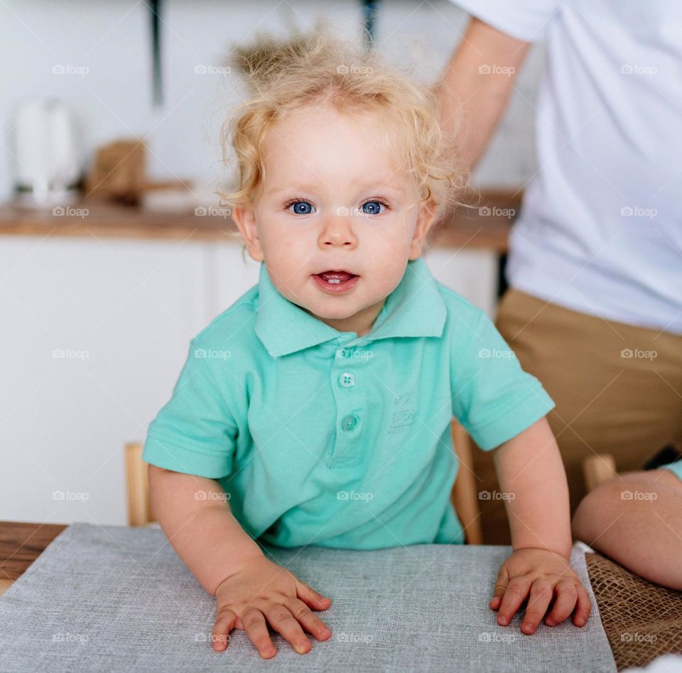 Portrait of cute little boy with curly blond hair and blue eyes. Candid moments