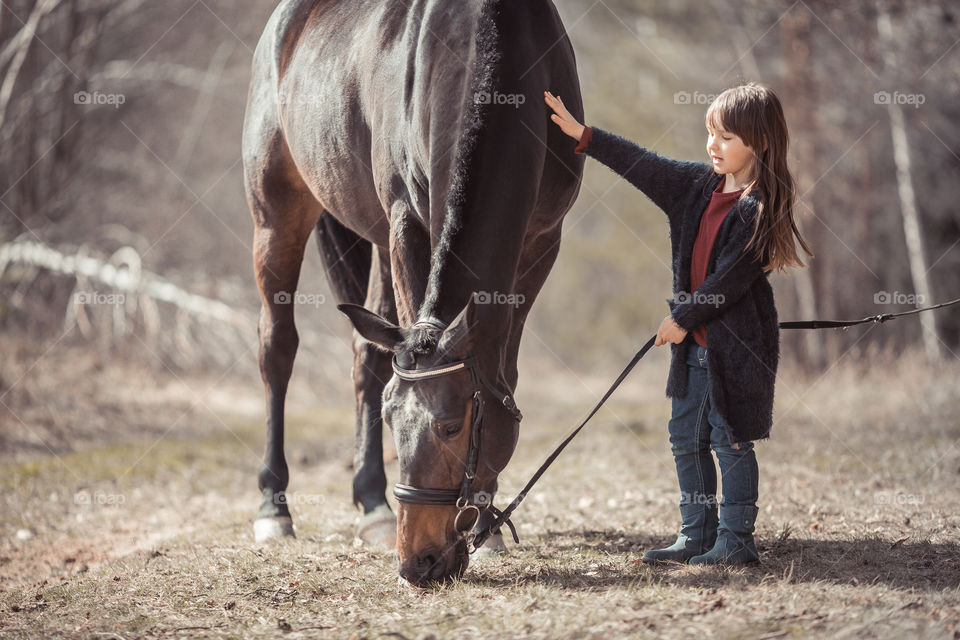 Little girl with horse, outdoor portrait 