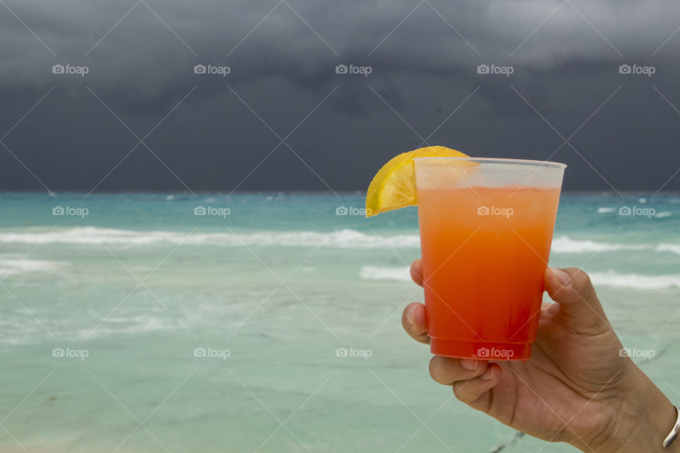 drinking tekila sunrise in caribbean beach