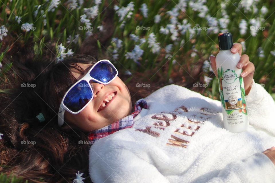 Cute little girl with long hair and herbal essences detangling cream