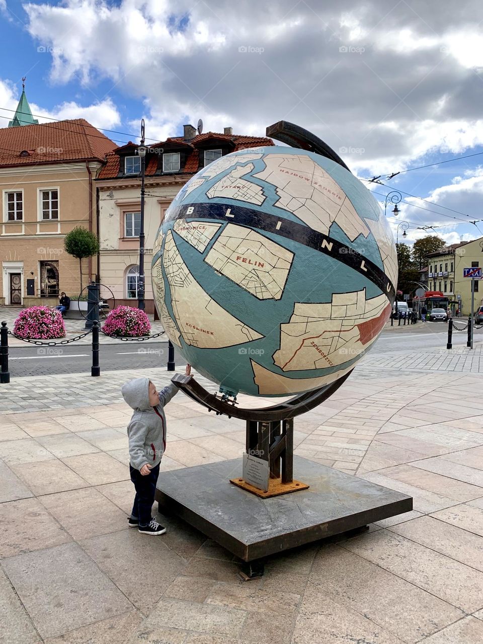 Little boy and big globe in the center of Lublin, Poland